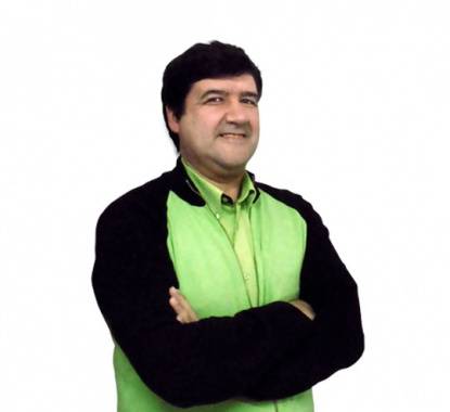 Diretor da loja Leroy Merlin Albufeira a sorrir com os braços cruzados e uma camisola verde