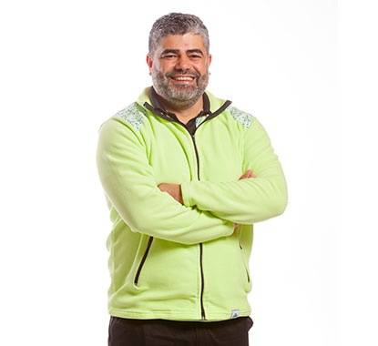 Diretor da loja LEROY MERLIN Penafiel a sorrir com os braços cruzados e uma camisola verde