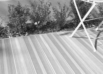 deck compósito num terraço com cadeira de jardim