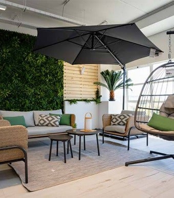 Ambiente com conjunto de sofás e mesa de centro, parede decorada com jardim vertical e paletes de madeira
